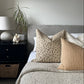 Top-down view of a bedroom decor with a bed, nightstand, and decorative printed cushions .