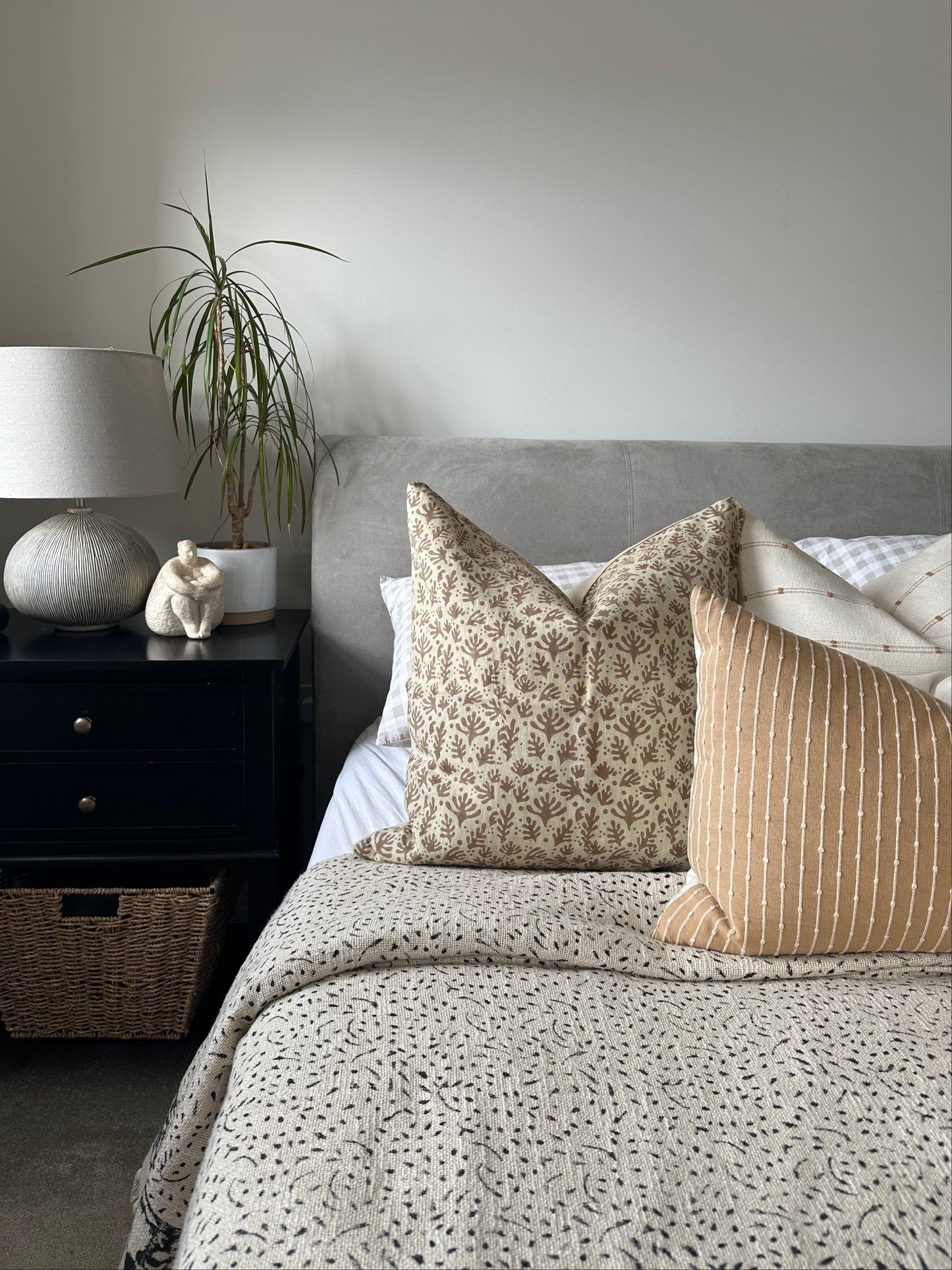 Top-down view of a bedroom decor with a bed, nightstand, and decorative printed cushions .